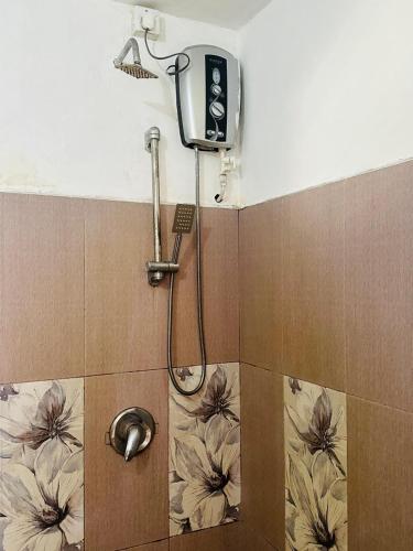 a shower in a bathroom with flowers on the wall at Rock View Hostel Ella in Ella
