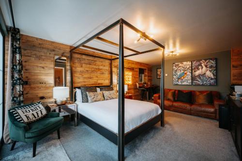 a bedroom with a canopy bed and a couch at Boutique Shrewsbury Suites in Shrewsbury