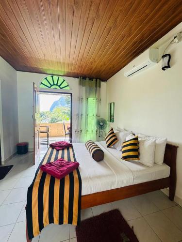 a bedroom with a large bed and a balcony at Rock View Hostel Ella in Ella