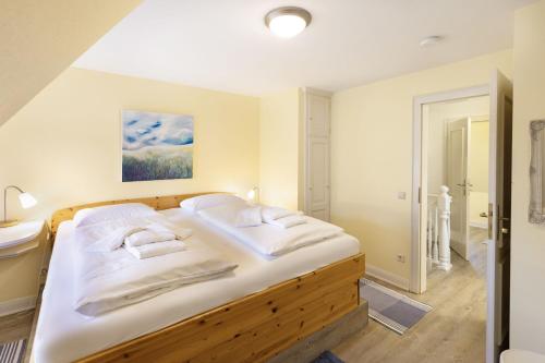 a bedroom with a large bed and a bathroom at Perle am Watt in List