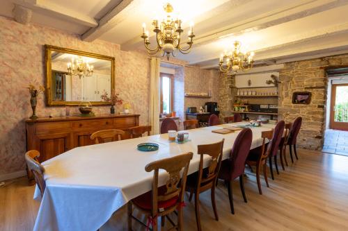 Chambres d'hôtes Les Charmettes في Rang: غرفة طعام مع طاولة طويلة وكراسي