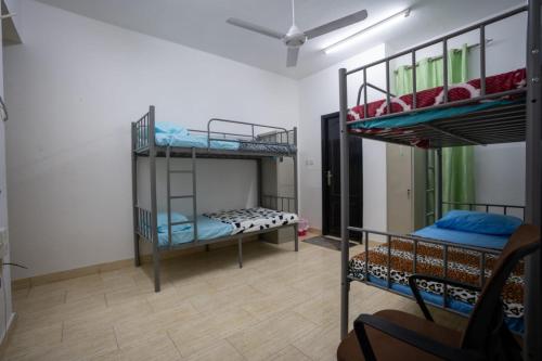 une chambre avec trois lits superposés dans l'établissement Mozna Hostel, à Mascate
