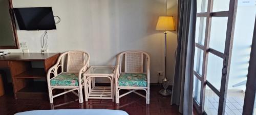 due sedie di vimini sedute accanto a una scrivania con un televisore di Puangpen Villa Hotel a Hua Hin