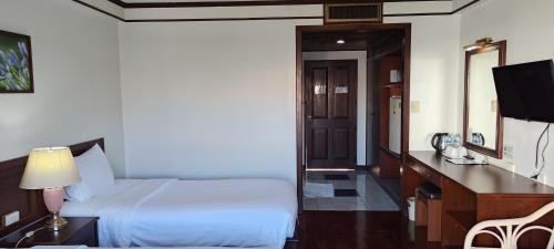a bedroom with a bed and a desk and a television at Puangpen Villa Hotel in Hua Hin