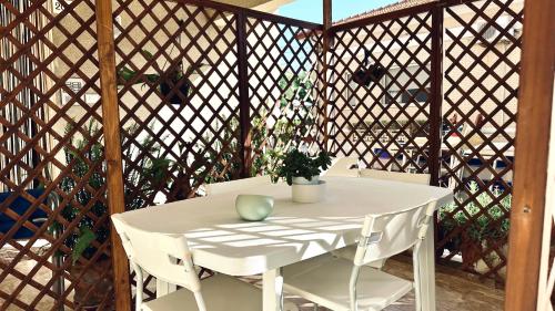 een witte tafel en stoelen op een prieel bij Bilocale fronte mare - RM08 in Senigallia
