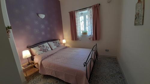 een slaapkamer met een bed en een raam bij Laura's Cottage in Calatabiano