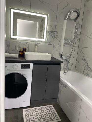 a bathroom with a sink and a washing machine at Modern Apartment in Chişinău