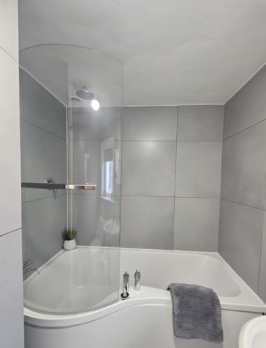 a white bathroom with a tub and a sink at The Exmouth Hideaway in Exmouth