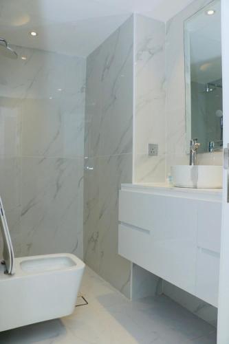 a white bathroom with a sink and a toilet at Dubai Marina larivera in Dubai