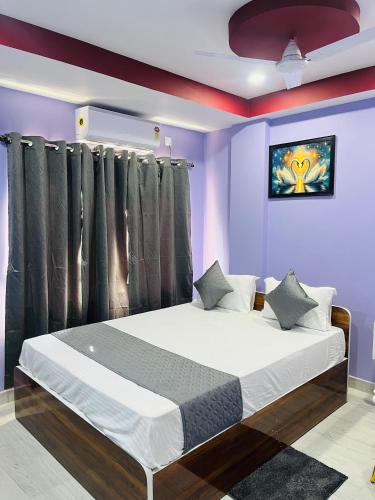 a bedroom with a large bed with purple walls at Hotel Sky Grand in Guwahati