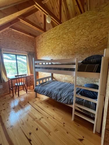 una camera con letti a castello e un tavolo in una stanza di Unique Farm Stay a Seafield