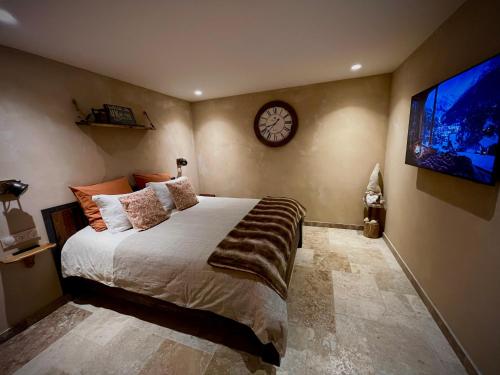 a bedroom with a bed and a clock on the wall at Haut Charmes de Cornil in Cornil