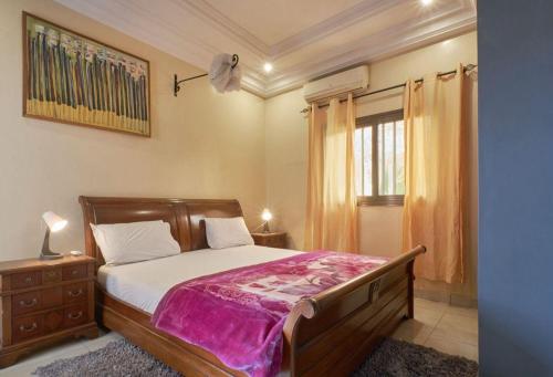 een slaapkamer met een bed en een raam bij Tekrour- La case des hotes -Chambre lumineuse proche plage in Mbour