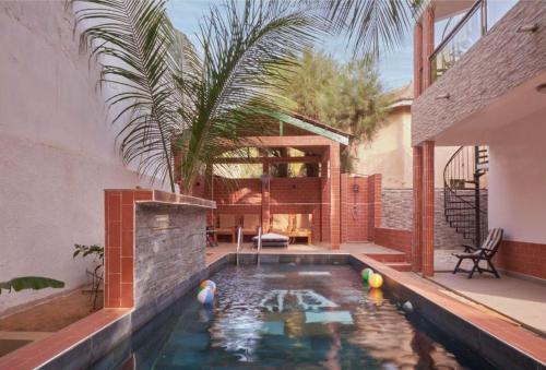 een zwembad in de achtertuin van een huis bij Tekrour- La case des hotes -Chambre lumineuse proche plage in Mbour