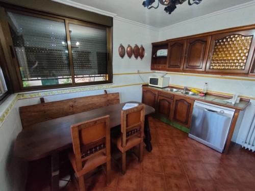 una cucina con un grande tavolo e sedie in legno di Casa Rural Ivanrey a Ivanrey