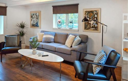 a living room with a couch and a table and chairs at 3 Bedroom Amazing Home In Hallaröd in Hallaröd