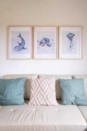four framed drawings of animals on a wall above a couch at Salitre - El Silencio Apartamentos in Castañeras