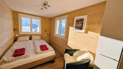 a small bedroom with two beds and a chair at Imhof Alpine B&B Apartments in Bettmeralp
