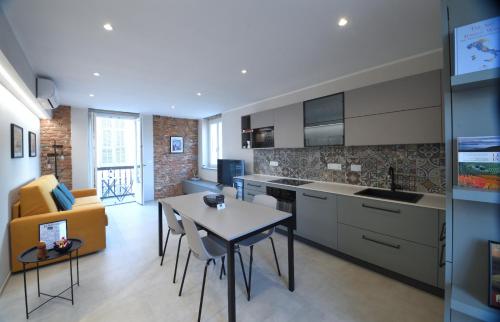 Casa PORTA LANERO di Francesco e Alessandro في نيتسا مونفيراتو: مطبخ وغرفة معيشة مع طاولة وأريكة