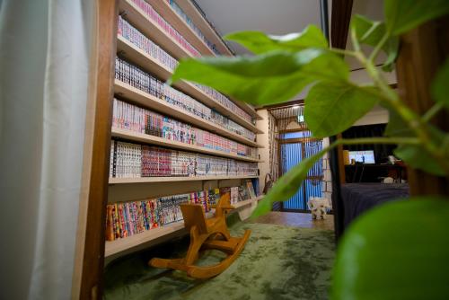 a room with a book shelf filled with books at 漫画のある家 in Yamatokoriyama