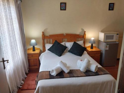 a bedroom with a bed with two towels on it at Lily Guesthouse in Bloemfontein