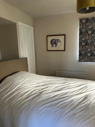 The Nest في بورن: سرير أبيض في غرفة نوم عليها صورة فيل