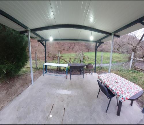 un patio coperto con un tavolo da ping pong e un tavolo da ping pong di Cabana Lunca a Lunca Ampoiţei