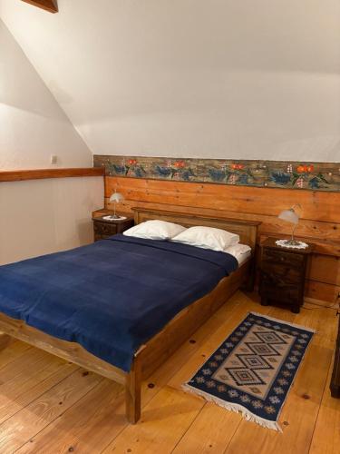 a bedroom with a bed and two night stands and two tables at Hriady in Wetlina