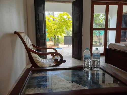a chair and two bottles of water on a table at villa Calm Haven in Unawatuna