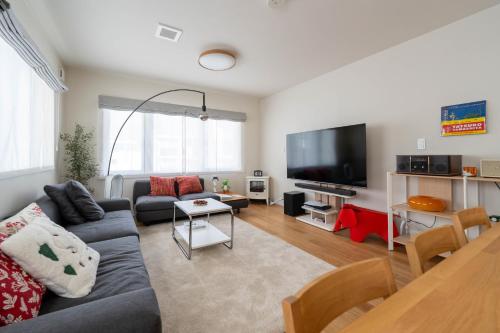 a living room with a couch and a flat screen tv at Mori Sapporo in Sapporo