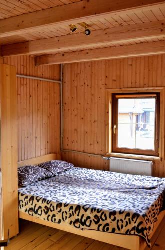 a bed in a room with a window at Садиба "Альпійській дворик" in Yablunytsya