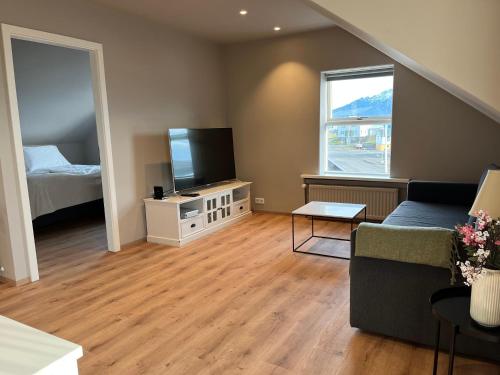 Una sala de estar con un sofá y un televisor de pantalla plana. en Hvammur Apartments by the Harbour, en Höfn