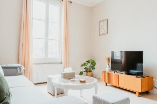 un salon avec un canapé et une télévision dans l'établissement À 2 Pas de la Plage Cosy et Super Équipé, au Havre
