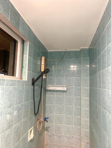 a shower in a bathroom with blue tiles at EC HomeStay in Tarlac