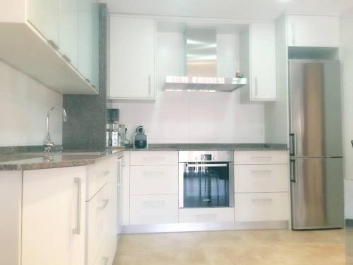 a kitchen with white cabinets and a stainless steel appliance at Cal Farre in Arbeca