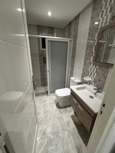 a bathroom with a toilet and a sink and a shower at Résidence Maha in Hammam Sousse