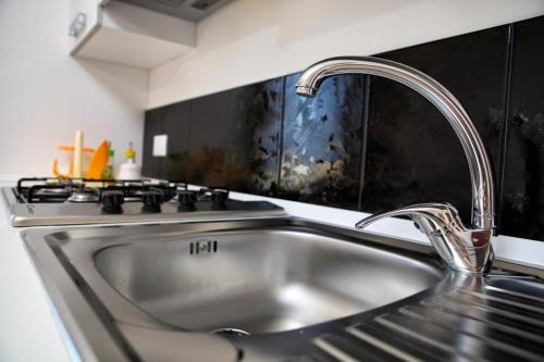a stainless steel sink in a kitchen next to a stove at Boa Vista San Vito - Area Fitness, Barbecue Area, Tennis Court in San Vito lo Capo
