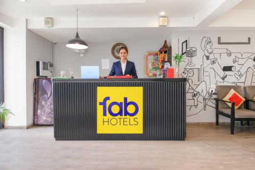 a woman is standing behind a table in an office at FabHotel Infinity Stays Near Medanta- The Medicity, Gurgaon in Gurgaon