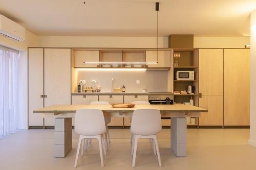 a kitchen with a large table and white chairs at Apartamento Sacadura Cabral - a 2 min da praia in Vila do Conde