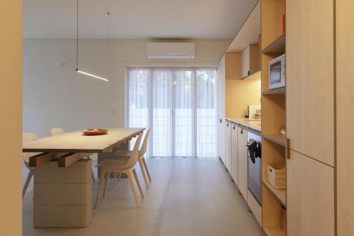 a kitchen with a table and chairs in a room at Apartamento Sacadura Cabral - a 2 min da praia in Vila do Conde