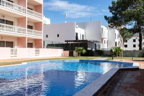 a swimming pool in front of a building at Parque dos Reis Apartment 4 A in Monte Gordo