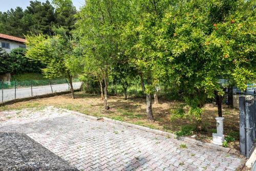 a garden with trees and a brick sidewalk at A28 - Poggio, trilocale vista mare in Ancona