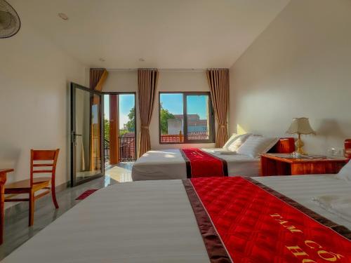 a hotel room with two beds and a window at Annamoi Homestay Tam Coc in Ninh Binh