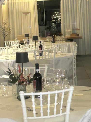 a table with glasses and a bottle of wine on it at Villa Marchese Lake Maggiore in Somma Lombardo
