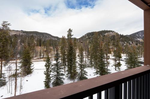 einen Balkon mit Blick auf einen schneebedeckten Wald in der Unterkunft 8858 The Springs Condo in Keystone
