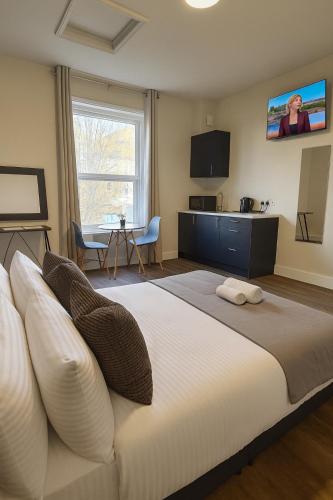 a bedroom with a large white bed and a kitchen at City Stays Norwich in Norwich