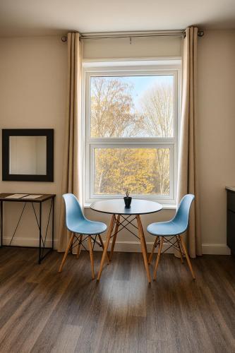 a dining room with a table and two chairs and a window at City Stays Norwich in Norwich