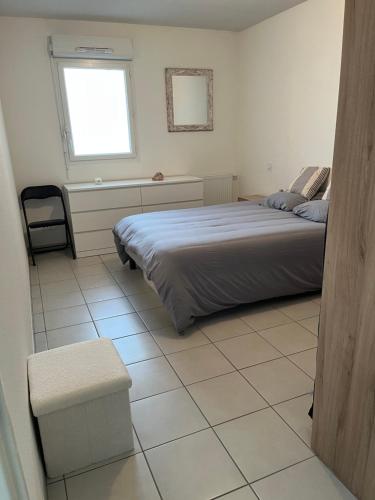 een slaapkamer met een bed en een tegelvloer bij Labenne Océan in Labenne