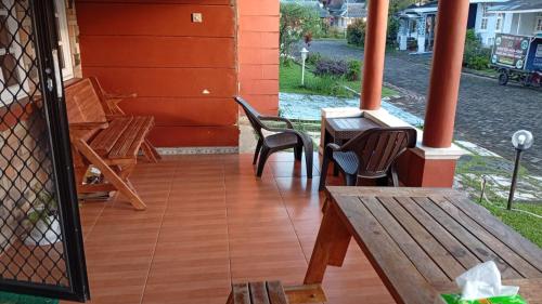 a porch with benches and a table and chairs at Villa Kota Bunga Q4-17 in Cikundul