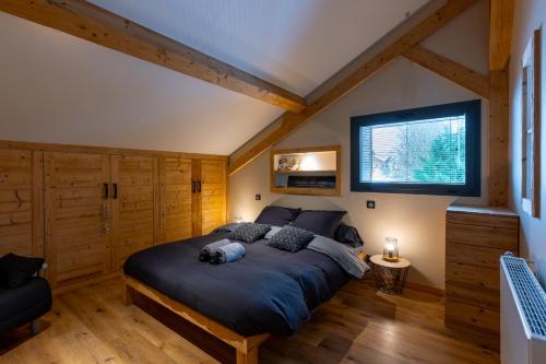 Un dormitorio con una cama grande en un ático. en La Fromagerie - Gîte d'exception à La Mouille, en La Mouille